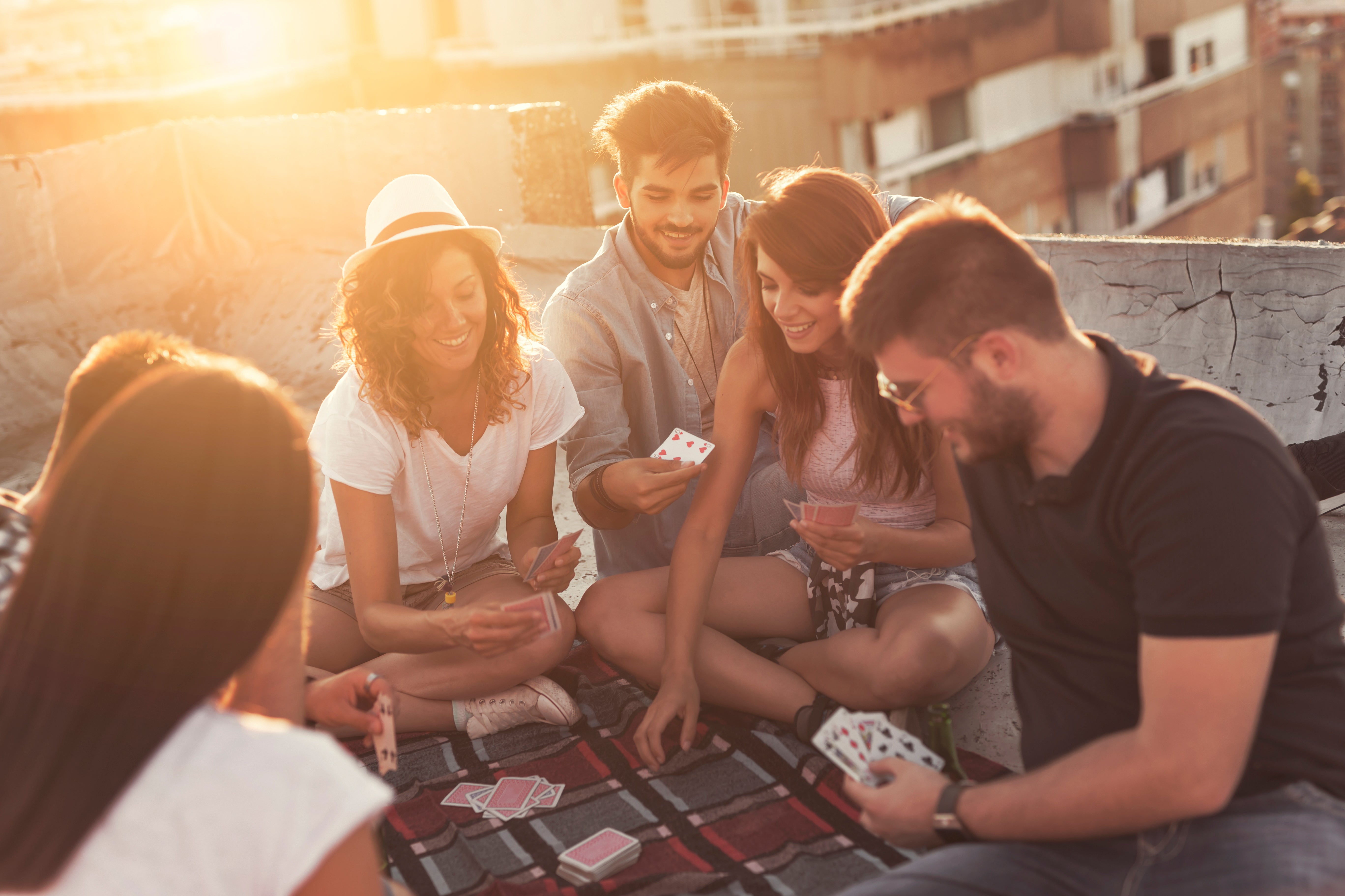 Friends enjoying a great card game in the evening on a rooftop